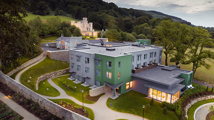 Overhead view of estate with new modern hotel in foreground and castle on the hill in background