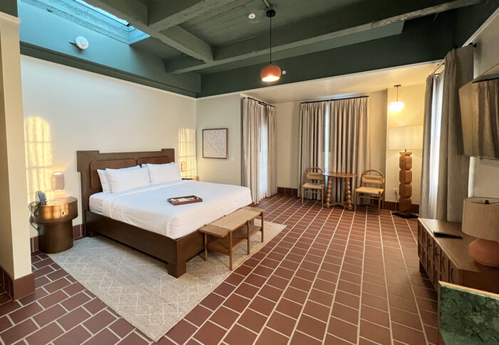 Hotel room with terracotta tiles on floor and vaulted ceiling and modern furniture