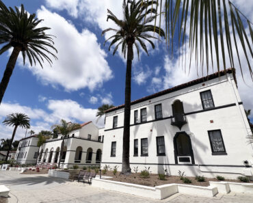 White Spanish Mediterranean building and terracotta roof with palm trees