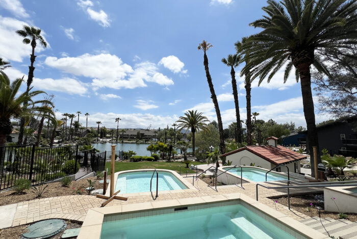 Blue tired small soaking pools above a lake with palm trees