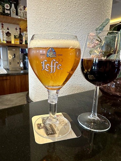 Leffe Blond beer and glass of merlot red wine at hotel bar. 