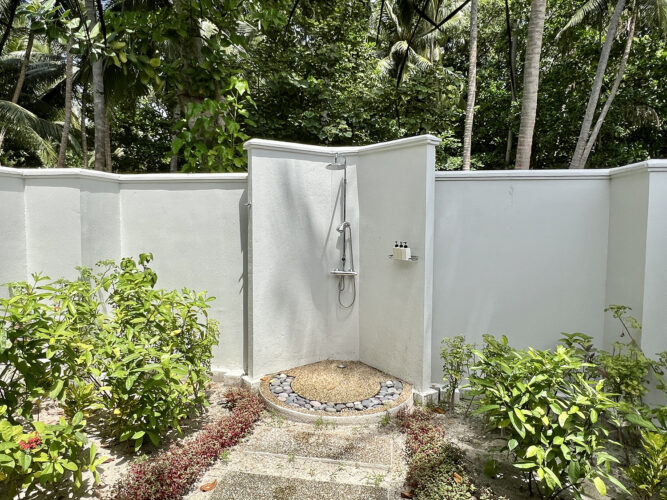 Hotel outdoor shower surrounded by tropical foliage