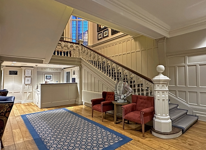 A grand carved staircase is the centerpiece of the Bishop's Gate Hotel's small lobby