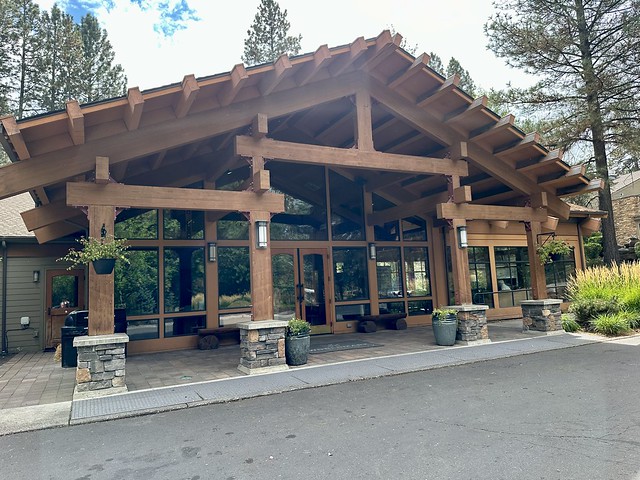 Seventh Mountain Resort reception with large wood beams and glass windows serving as the entrance to the stately log building. 