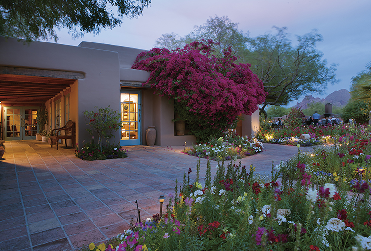 An exterior view of adobe Hermosa Inn, covered in flowers