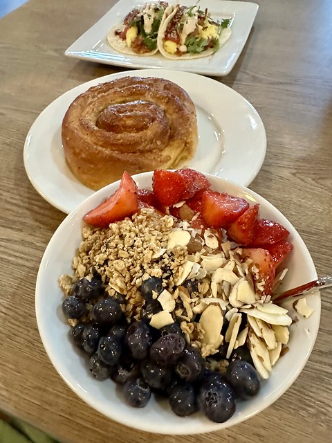 Greek yogurt with blueberries, granola, shaved almonds and strawberries. Sparrow Bakery Ocean Roll pastry. Last plate holds 2 breakfast tacos from Franklin restaurant.