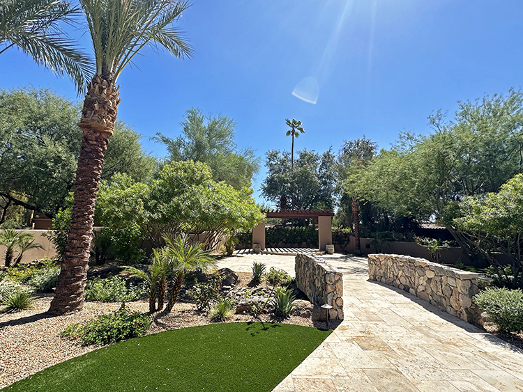 An expansive garden showcases lush plantings and a pergola and patio that are ideal for weddings.