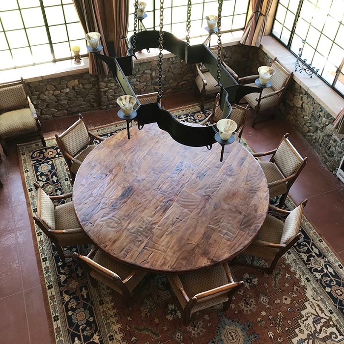 A massive handmade wood table complements a handcrafted iron chandelier in the dining room. 